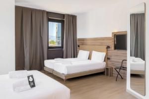 Ένα ή περισσότερα κρεβάτια σε δωμάτιο στο B&B HOTEL Prato City Center