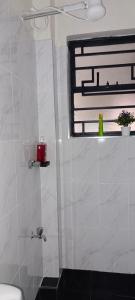 une salle de bain avec douche et fenêtre dans l'établissement BlueByMis, à Muchatha
