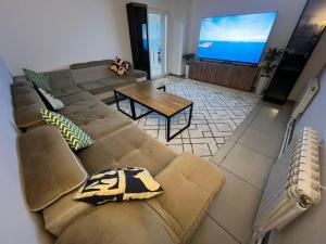 比什凯克Meeting Place Bishkek的客厅配有棕色沙发和电视