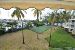 a tennis court with palm trees in a park at studio hôtel Caraypu in Lazaret +13 photos