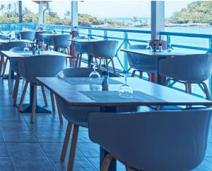 a row of tables and chairs in a restaurant at studio hôtel Caraypu in Lazaret