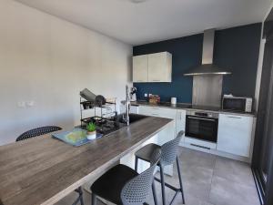 Bras-PanonArbre à pain的厨房配有木制台面和椅子