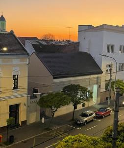 una calle de la ciudad con coches estacionados frente a los edificios en Gabriela Studio Central, en Satu Mare