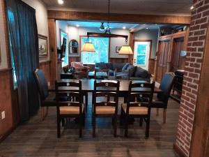 a dining room and living room with a table and chairs at Spacieuse propriété pour grande famille avec activités et spa 10 p in La Macaza