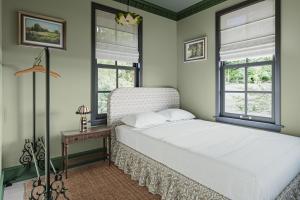 1 Schlafzimmer mit einem weißen Bett und 2 Fenstern in der Unterkunft Wild Indigo - Upscale 2 Bedroom Villa at Petite Acres in New Buffalo