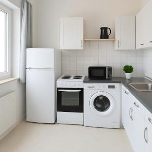una cucina bianca con frigorifero e lavatrice di Apartment für Monteure in Merseburg a Merseburg