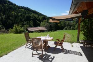 a patio with a table and chairs and a bench at Bodenschneidsuiten Das Gschwandler in Tegernsee