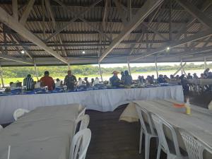 Un grupo de personas sentadas en mesas en una tienda de campaña. en Residencial Romulo Ap 4, en Manaus 35 fotos más