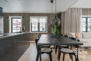 een keuken en woonkamer met een tafel en stoelen bij The Black Bear Lodge in Tällberg