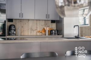 een keuken met witte kasten en een aanrechtblad bij The Black Bear Lodge in Tällberg