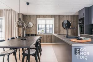 een keuken met een grote houten tafel en stoelen bij The Black Bear Lodge in Tällberg