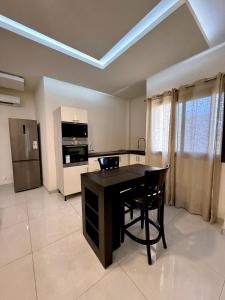 a kitchen with a black table and a black chair at Appart'Hotels TEK & TEY in Dakar