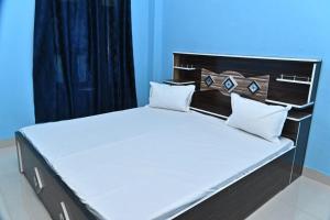 a bed with white sheets and pillows in a room at Royal hotel in Hardoī