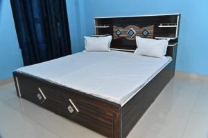 a large bed with a wooden headboard and white sheets at Royal hotel in Hardoī +15 photos