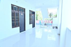a hallway with black doors and white floors at Royal hotel in Hardoī