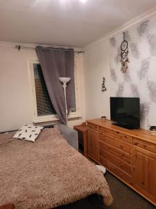 a bedroom with a bed and a television on a dresser at Sunny ROOM in Stockholm in Stockholm
