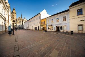 an empty street in a city with buildings at Cute Apartment in the heart of Old Town in Košice