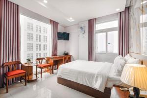 ein Hotelzimmer mit einem Bett, einem Schreibtisch und einem Fenster in der Unterkunft Kiên Cường 2 Hotel in Đà Nẵng + 226 Fotos