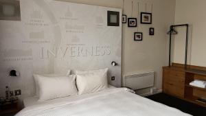 Un dormitorio con una cama grande con almohadas blancas. en B&B HOTEL Inverness, en Inverness