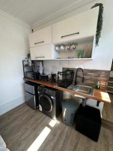 a kitchen with a sink and a washing machine at Studio Seabiscuit in Cape Town +6 photos