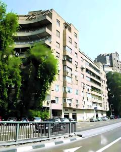 un edificio con coches aparcados frente a una calle en Coze Suite Nile River, en El Cairo
