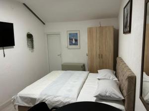 Un dormitorio con una cama grande con dos almohadas. en Apartmani BALKAN, en Sjenica
