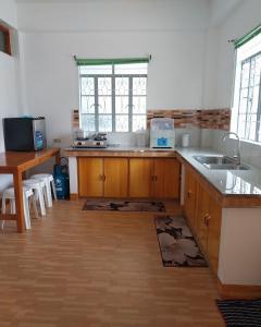a kitchen with wooden cabinets and a sink and a table at Ag-agongan Lodge in Baguio