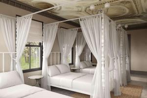 Pied A Terre - Bunk House Villa at Petite Acres في نيو بافالو: سريرين في غرفة نوم مع ستائر بيضاء وسقف