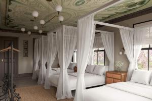 Pied A Terre - Bunk House Villa at Petite Acres في نيو بافالو: غرفة نوم بها أربعة أسرة مظلة وسقف مجوف