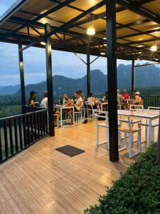 a group of people sitting at tables on a deck at Khaosok Campsite in Khao Sok National Park