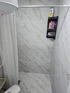 a bathroom with a white marble wall at Studio modern 10 min de centru, perfect pentru doi in Chişinău +12 photos