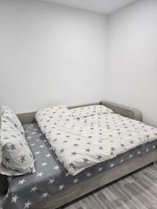 a bed sitting in a room with a gray bed frame at Studio modern 10 min de centru, perfect pentru doi in Chişinău