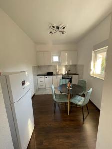 a kitchen with a table and chairs and a refrigerator at M&M Trebinje in Trebinje