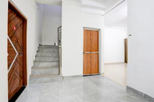 a hallway with a wooden door and stairs at Hotel O Ayushman in Jabalpur