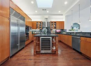 cocina grande con armarios de madera y electrodomésticos de acero inoxidable en Elegant Three-Bedroom Beachfront Home With Wide Ocean Views, en Redondo Beach