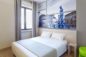a bedroom with a white bed and a picture of a statue at B&B Hotel Firenze Novoli in Florence