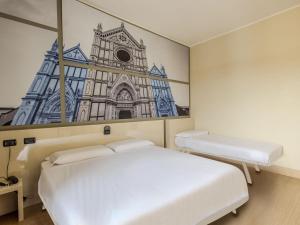 ein Schlafzimmer mit einem weißen Bett und einem Bild einer Kirche in der Unterkunft B&B Hotel Firenze Novoli in Florenz