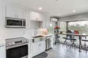 eine Küche mit weißen Schränken und einem Tisch und Stühlen in der Unterkunft Luxury Waterfront property in Bay Saint Louis