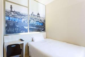 ein Hotelzimmer mit 2 Betten und einem Bild an der Wand in der Unterkunft B&B Hotel Firenze Novoli in Florenz