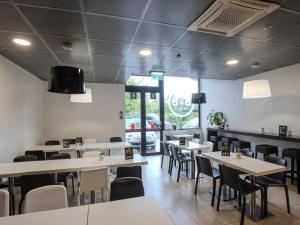 ein Esszimmer mit weißen Tischen und Stühlen in der Unterkunft B&B Hotel Firenze Novoli in Florenz + 11 Fotos