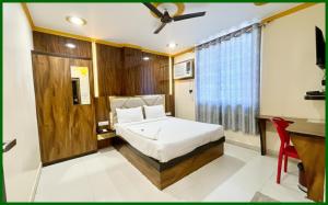 a bedroom with a bed and a desk and a window at Hotel Upajivan RudraInn Near vishwanath temple # Free wifi # Lift - Best Premium Hotel in Varanasi