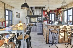 een keuken met tafels en stoelen in een kamer bij Vivez dans cet ancien semaphore avec vue mer in Les Sables-dʼOlonne