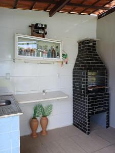 una cucina con un forno in mattoni neri in una stanza di Casa de praia em Barra do Gil a Vera Cruz de Itaparica Altre 29 foto