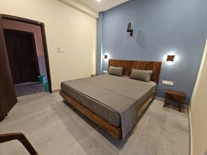 a bedroom with a bed and a blue wall at Tavāsmi in Puri +30 photos