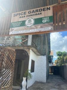 桑给巴尔Spice Garden Lodge B&B的建筑物侧面的标志牌上画着一个花瓶
