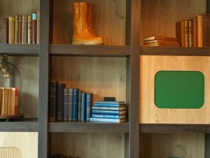 a book shelf filled with books and a green monitor at B&B HOTEL Ipswich in Ipswich