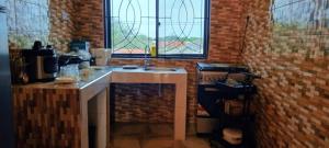 cocina con fregadero y pared de ladrillo en Jmapartment and shopping center, en Matemwe