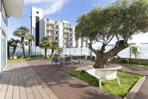 una mesa, sillas y un árbol frente a un edificio en B&B Hotel Savona, en Savona 30 fotos más