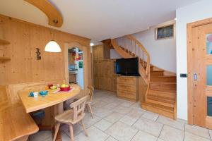 a kitchen and dining room with a table and a staircase at Art Apartments Kandinsky in Livigno