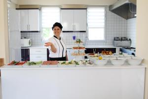 a woman standing in a kitchen preparing food at Fethiye Pansiyon in Fethiye